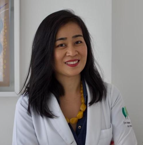Retrato da Dra. Sumika Mori, geriatra, de jaleco branco no consultório da Goki Geriatria em São Paulo